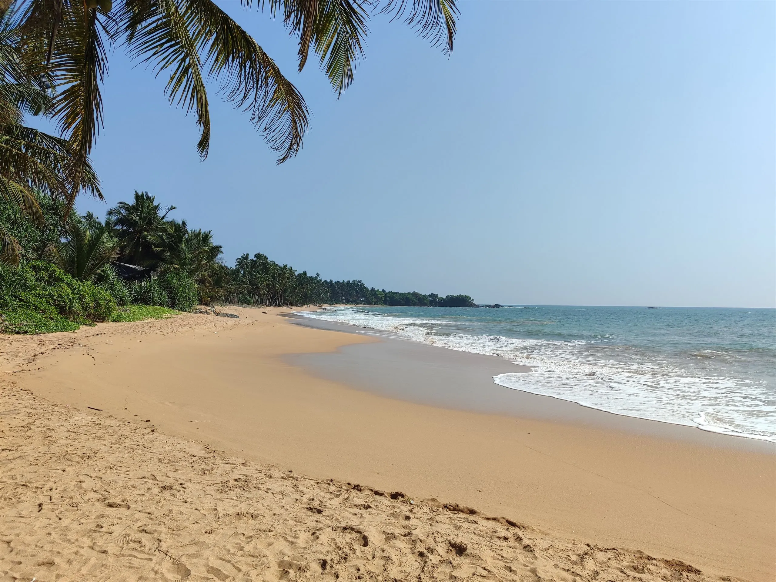 A wide, near-empty sandy beach on the west coast