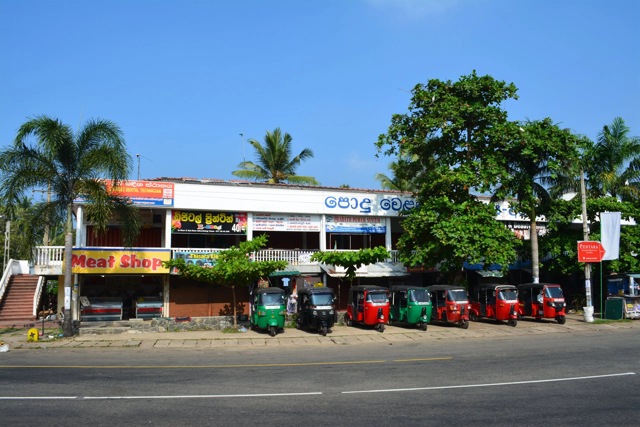 Tuk-tuks lined up outside the shops on the main road through town