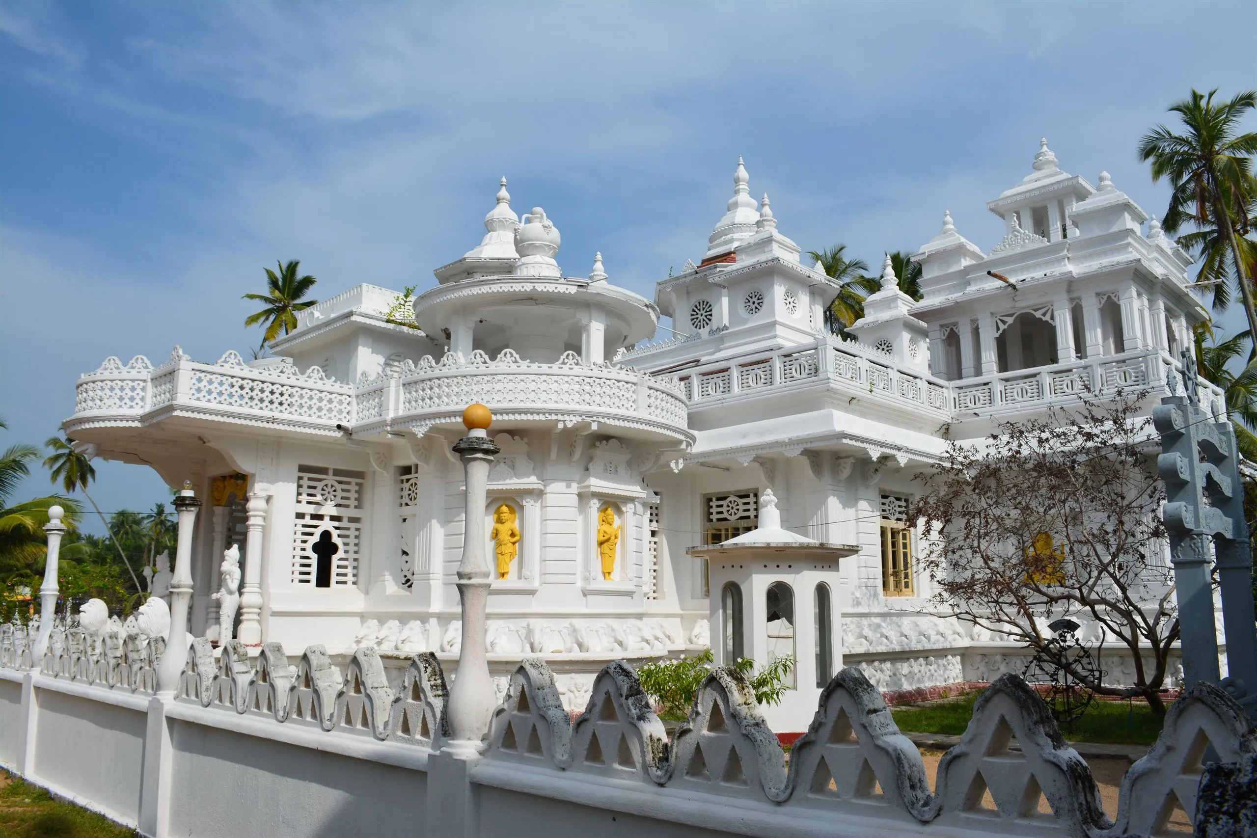 An all-white temple with carved balustrades and gilded figures