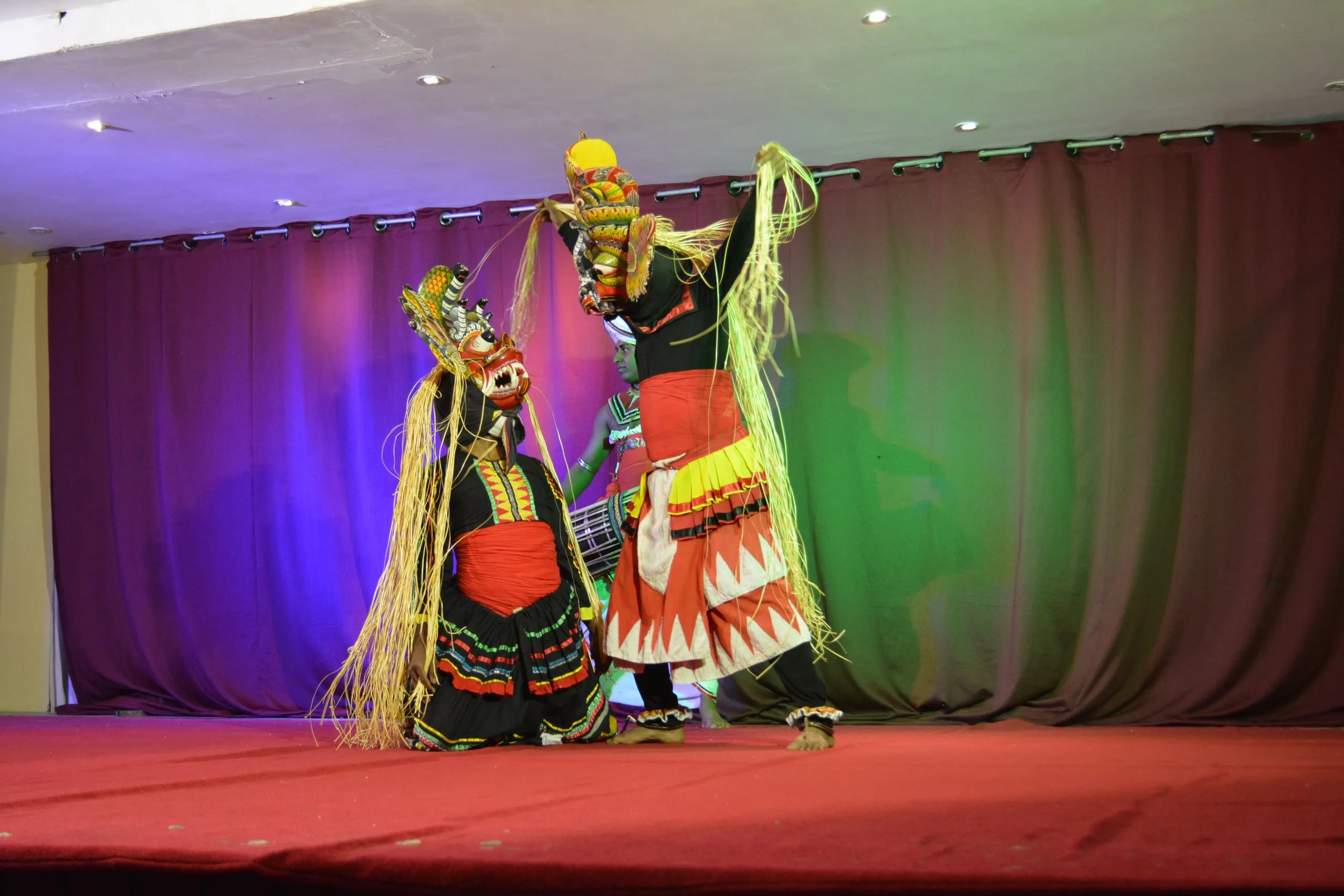 Two masked Kandyan dancers on stage